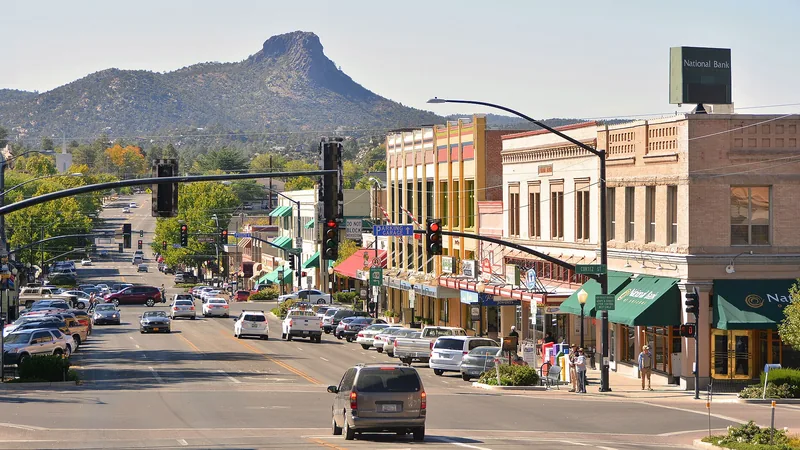 Gurley Street in downtown Prescott lined with historic storefronts, with Thumb Butte on the horizon