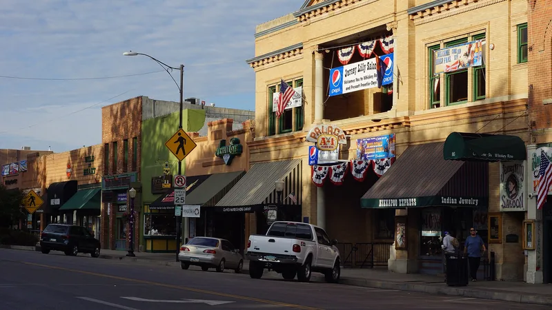 Historic brick and stone storefronts of Whiskey Row on Montezuma Street, including the Palace saloon building, in late-afternoon light